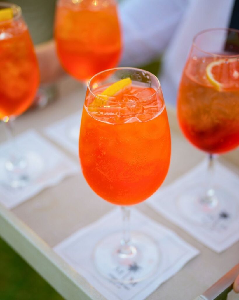 Vibrant orange cocktails served during golden hour at a Fairchild Tropical Garden wedding.