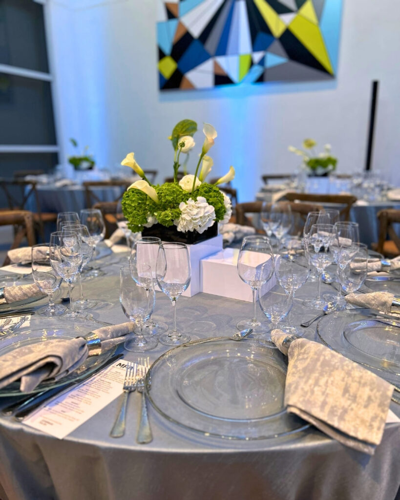Elegant dinner table setup at The Bass with floral centerpiece and geometric artwork