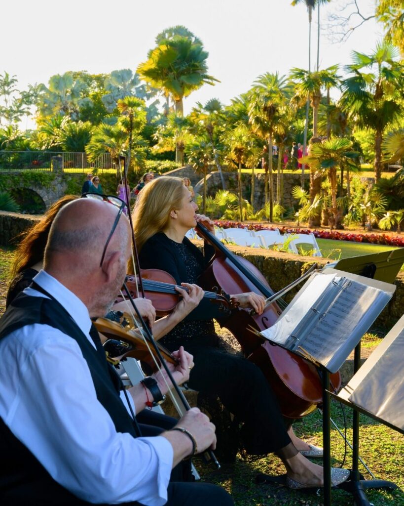 String quartet performing live music during an outdoor wedding ceremony at Fairchild Tropical Botanic Garden.