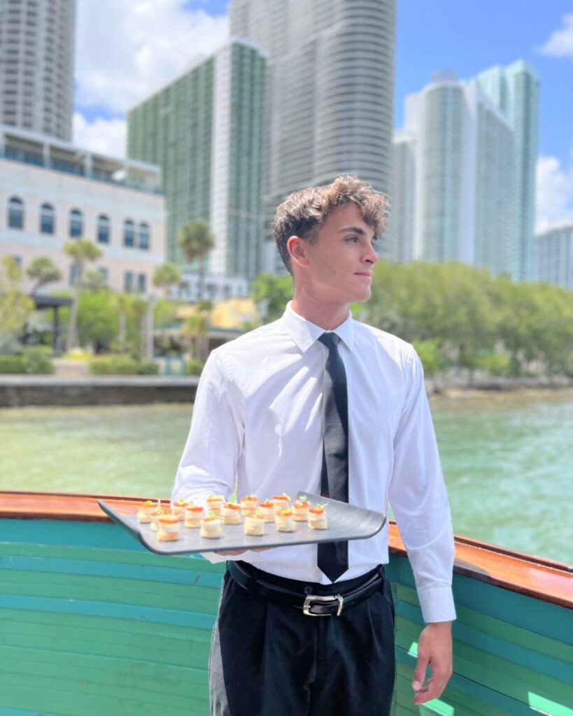 Server with canapés overlooking Miami skyline at Dolce & Gabbana event
