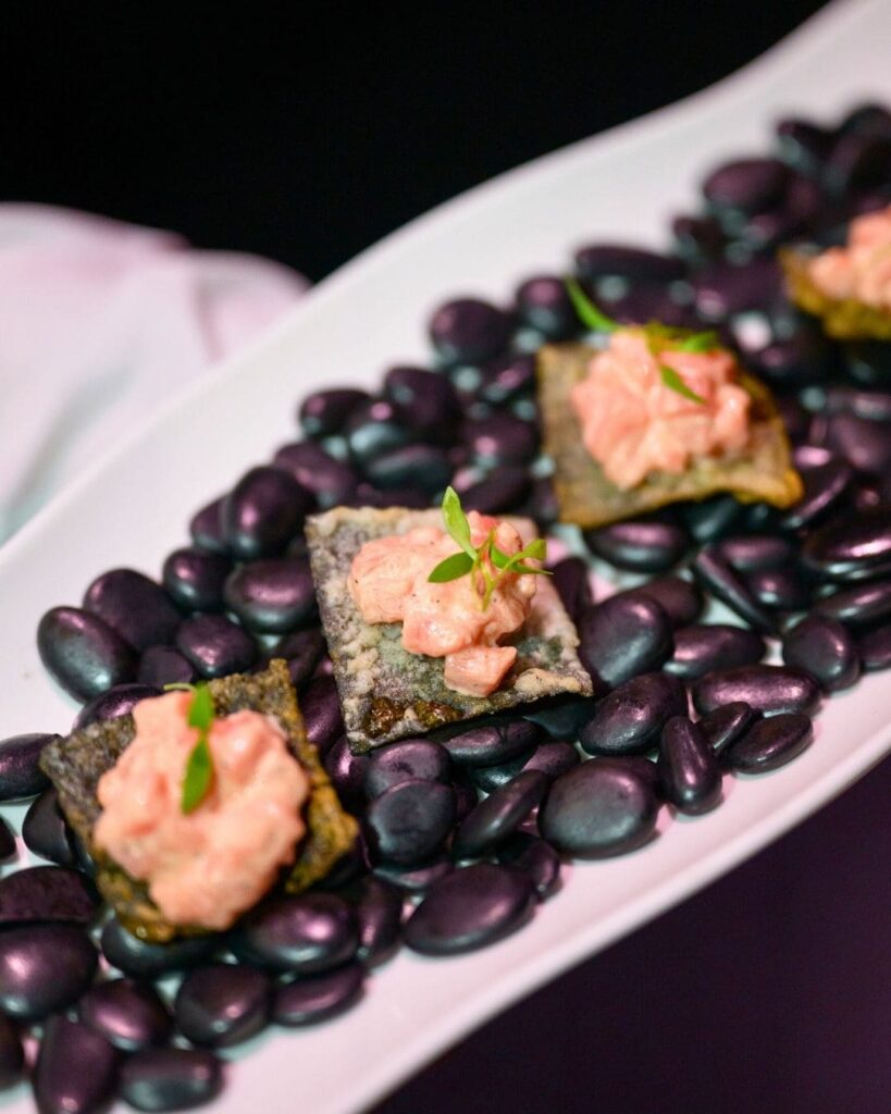 Salmon tartare canapés presented on dark river stones
