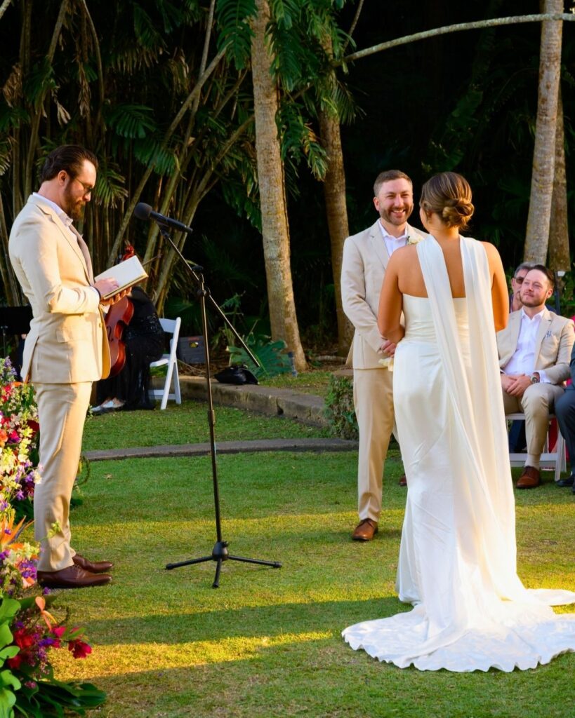 Bride and groom exchanging vows under the palms at Fairchild Tropical Botanic Garden wedding ceremony.