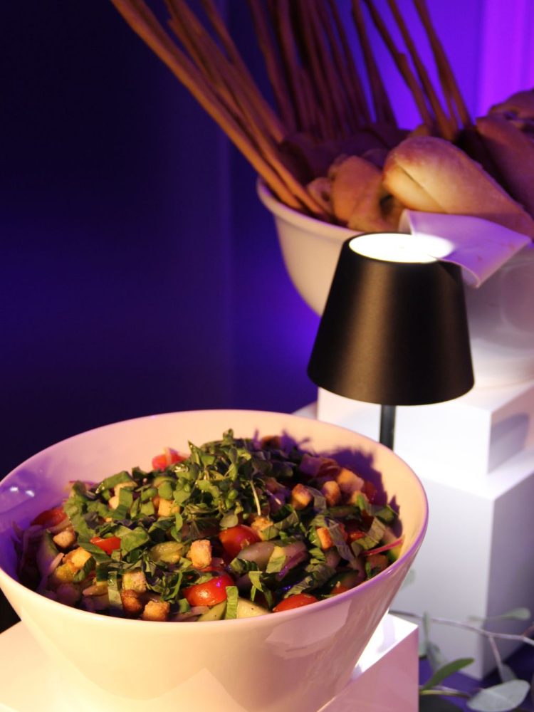 Fresh salad with tomatoes, greens, and croutons in a white bowl.