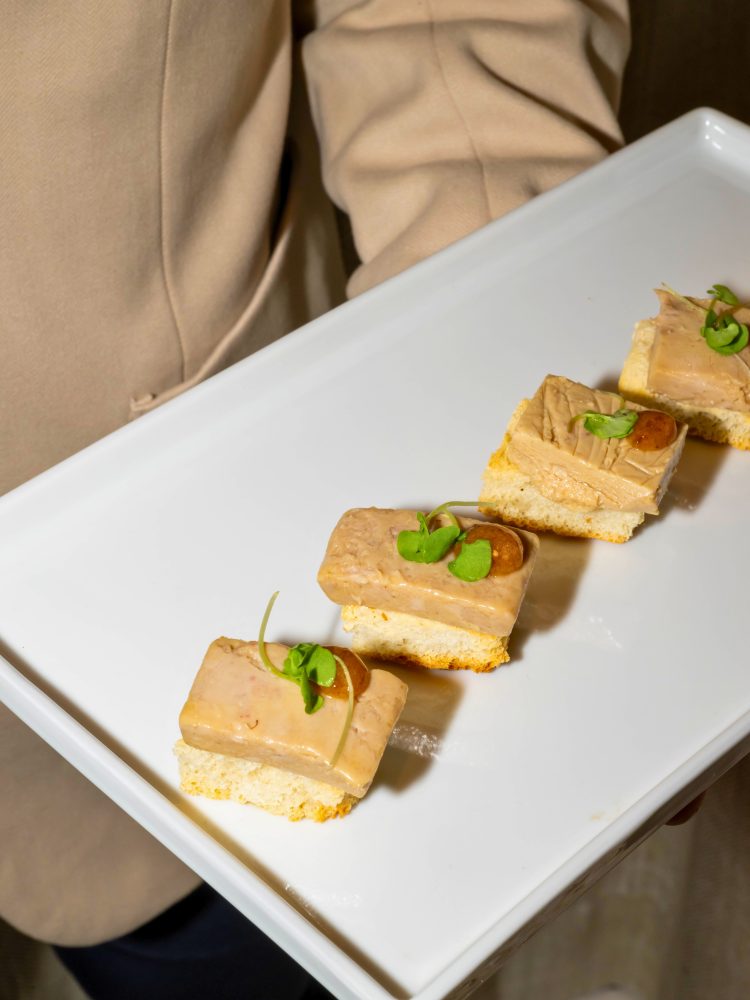 Foie gras appetizers on brioche toast with microgreens at a Miami luxury event.