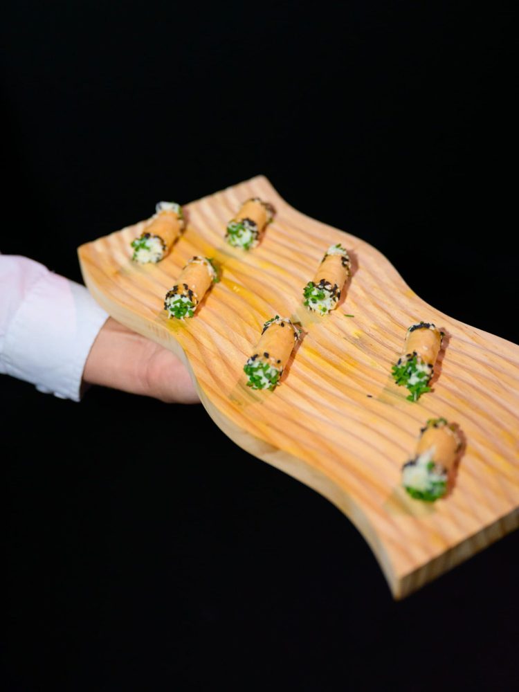 Gourmet rolled hors d’oeuvres garnished with herbs and sesame seeds.