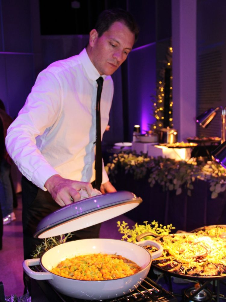 Catering staff serving a dish at a luxury buffet.