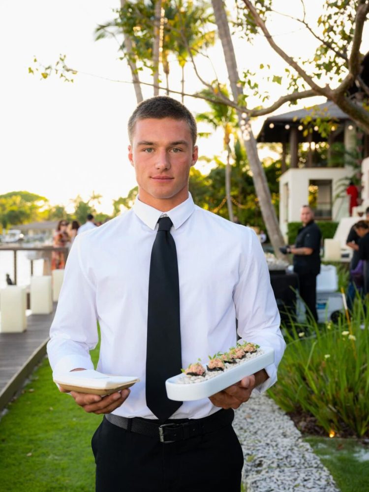 UCD server holding gourmet hors d’oeuvres at outdoor luxury event